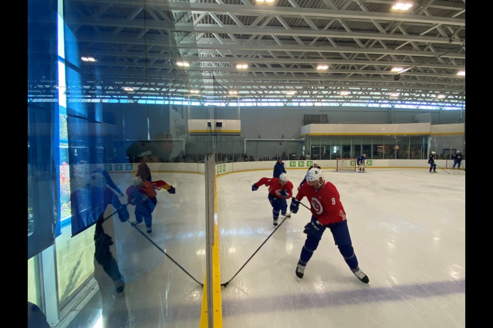 Canucks Star JT Miller picks up a puck along the boards during a drill on Saturday at Meadow Park.