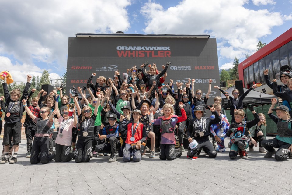 Young riders aged 7 to 12 pile onto the podium in Skiers Plaza after the 2023 Kidsworx Enduro.