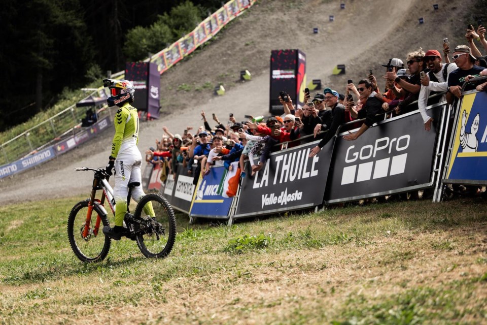 Jackson Goldstone stands on his mountain bike as fans cheer on his World Cup victory on July 6, 2025 in La Thuile, Italy.