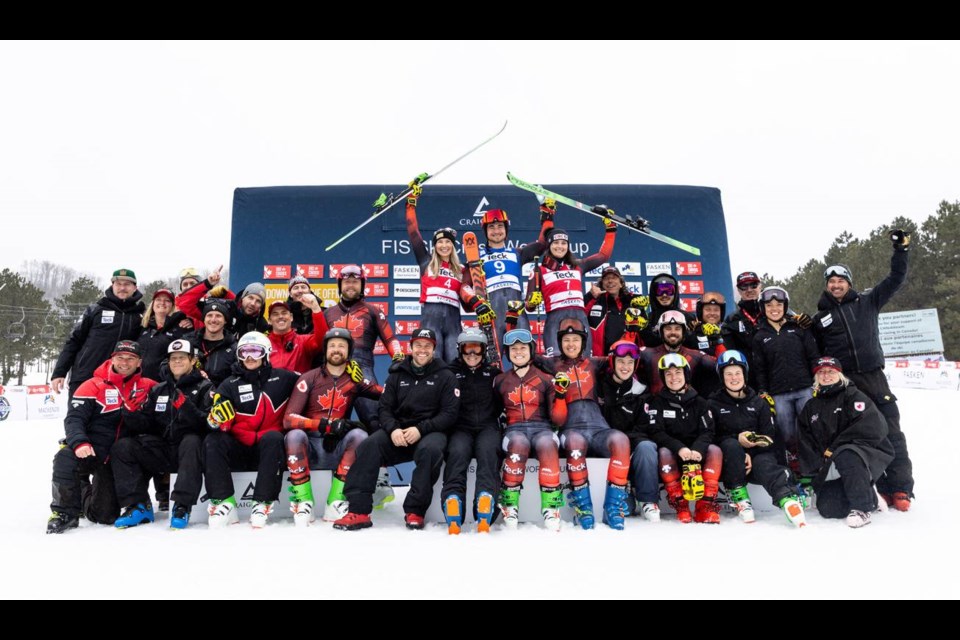 Marielle Thompson (bib no. 7) stands with Reece Howden (bib no. 9) and the rest of the Canadian ski cross team after winning bronze at the World Cup final on March 17, 2023. 