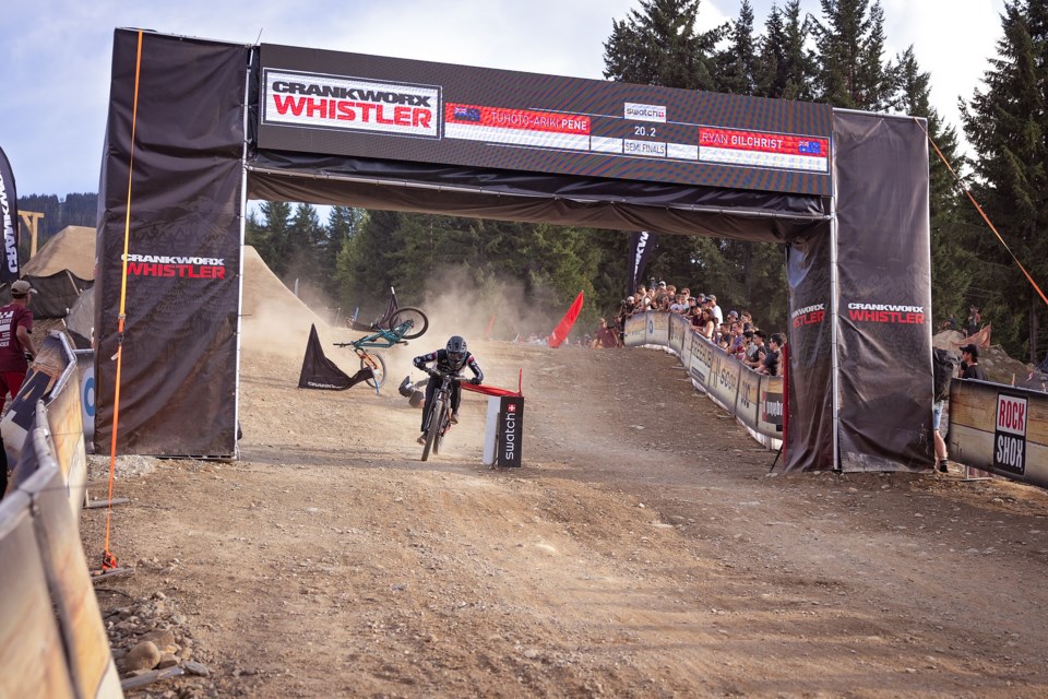 Tuhoto-Ariki Pene breaks the beam (after missing a gate) as Ryan Gilchrist wipes out during a semifinal at the 2023 Crankworx Dual Slalom. 