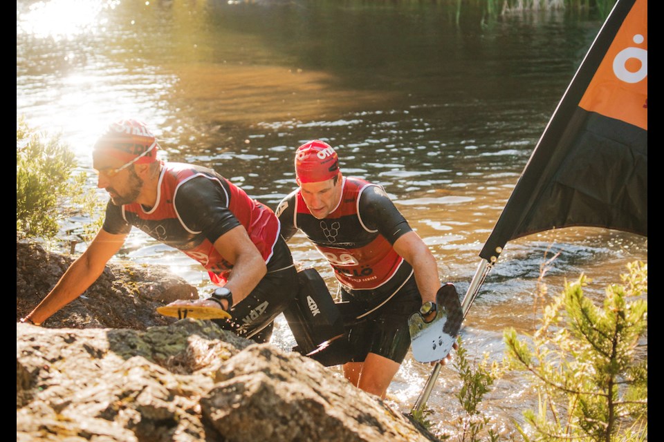 Two men emerge from the water at the first Swimrun Whistler contest on July 7, 2024.