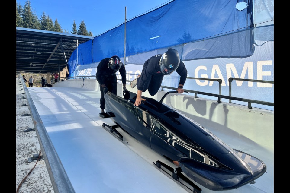 Team Canada brakeman Cyrus Gray hops into a boblsed behind  pilot Taylor Austin during a pre-season training session at the Whistler Sliding Centre in October 2022.