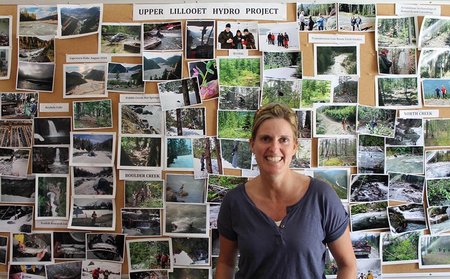 Wall of Work: Innergex project manager Natalie Closs in front of a wall of photos from the company's Upper Lillooet run-of-river project. Photo by Cathryn Atkinson