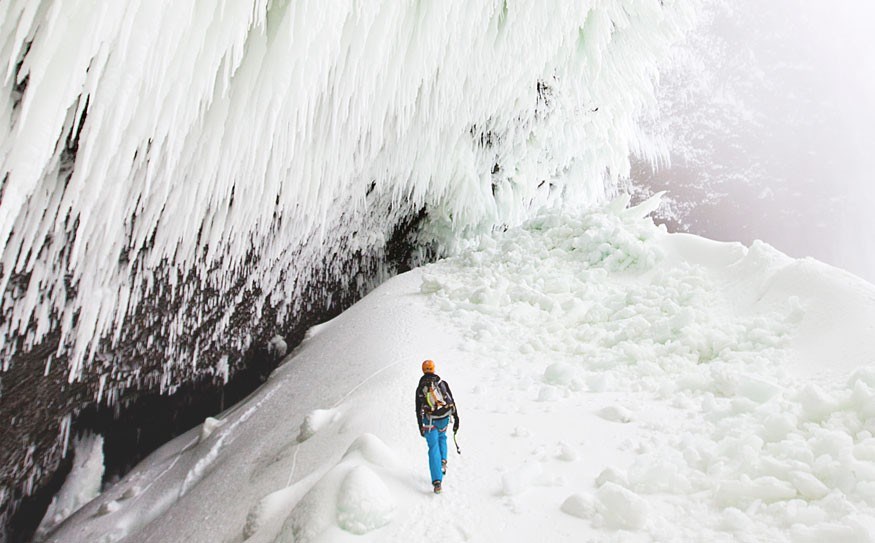 Tim Emmett walking through the blocks of ice towards the base of Helmcken Falls, British Columbia. Here, the climbing route called 'Wolverine' is the world's only known example of a WI11 grade (system which measures the difficulty of routes on water ice). This ranking denotes previously unheard of climbing running steep to horizontal through fragile stalactites of spray ice. Photo by Chris Christie.