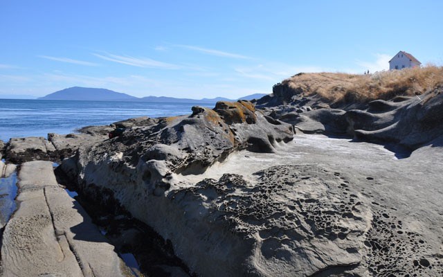 Outcroppings at Saturna Island's East Point with the restored Fog Alarm Building. Photo by Louise Christie