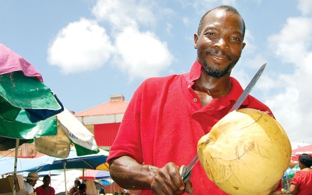 Rodins 'Boss Man' George will machete open a coconut so you can sip refreshing coconut water. Photo by Steve MacNaull