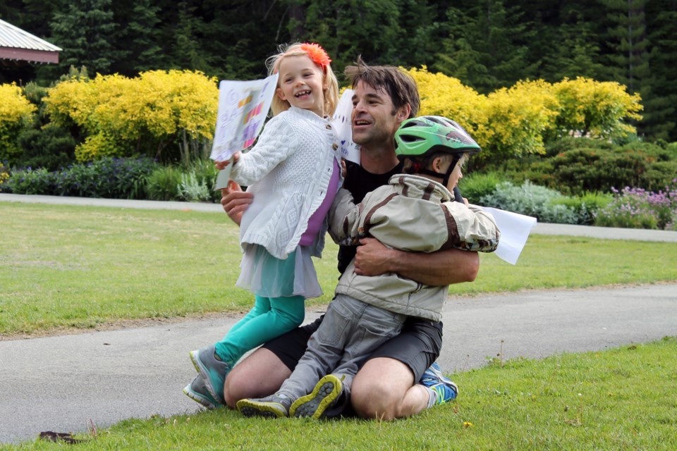 Whistler's Adam Mercer is greeted by children Xanadu and Devon at the finish line of the Whistler Valley Trail Run on Father's Day. Photo by Eric MacKenzie