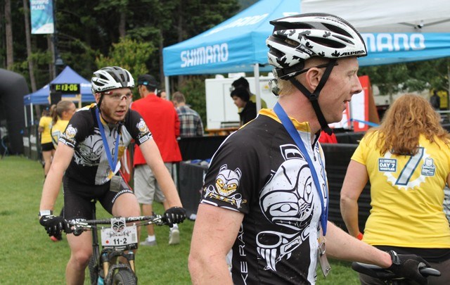 Squamish riders Quinn Moberg, left, and Greg Day reach the BC Bike Race finish in Whistler as Epic Open Team of 2 champs on Saturday, July 5. Photo by Eric MacKenzie