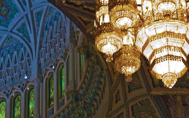 A gigantic chandelier hangs from the central dome in the Sultan Qaboos Grand Mosque. Photo by Greta Gabaglio / <a href="http://shutterstock.com/">Shutterstock.com</a>