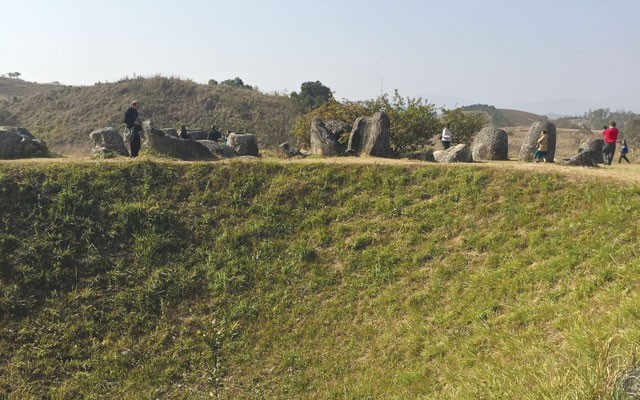 MAN'S INGENUITY ON DISPLAY Visitors to Laos' Plain of Jars Site 1 walk around the edge of a massive bomb crater. Photo by Leslie Anthony