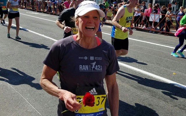 A RACE AND A ROSE Christine Suter holds a rose in memory of friend Sarah Prunier at the Boston Marathon, which she raced last month. Photo submitted