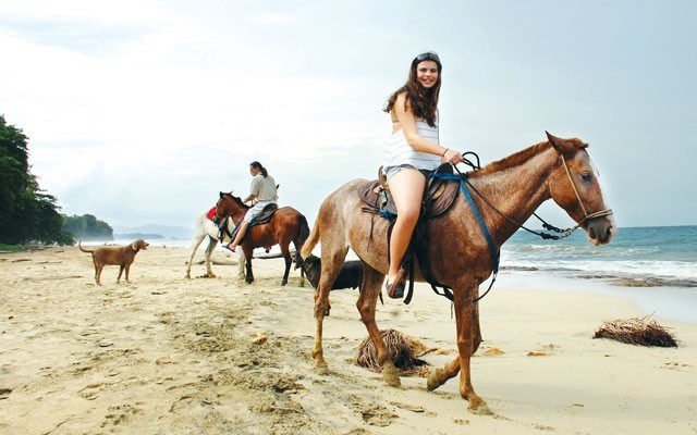 Grace MacNaull, 13, atop Tiko, with tour guide Bruce Walker on Tia during a ride along Punta Uva Beach in remote southeast Costa Rica. photo by steve macnaull