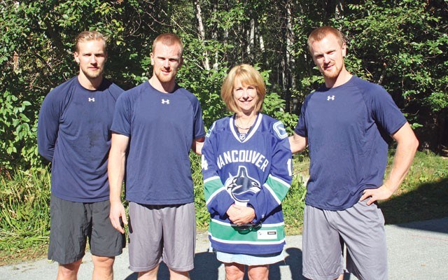 RETURN TRIP Mayor Nancy Wilhelm-Morden is shown with Vancouver Canucks players Alex Edler, Henrik Sedin and Daniel Sedin during the team's last visit in 2014. File photo by Braden Dupuis