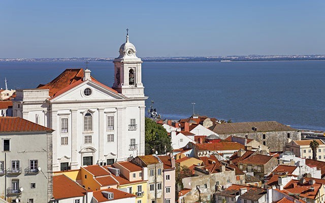 Alfama District with Santo Estevao Church and the Tagus River estuary seen from Miradouro de Santa Luzia. Lisbon, Portugal. <a href="http://shutterstock.com">shutterstock.com</a>