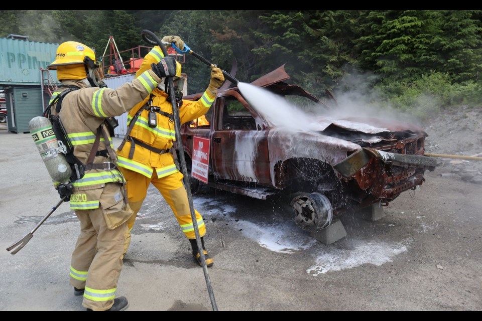 BLAZING HOT Pique reporter Braden Dupuis puts out a car fire. <ParaStyle:CUTLINE\:CUTLINE Credit>Photo by Megan Lalonde