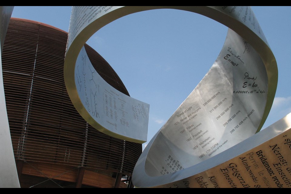 Canadian artist Gayle Hermick's ribbon sculpture frames CERN's giant wooden Globe of Science and Innovation. Photo by Glenda Bartosh