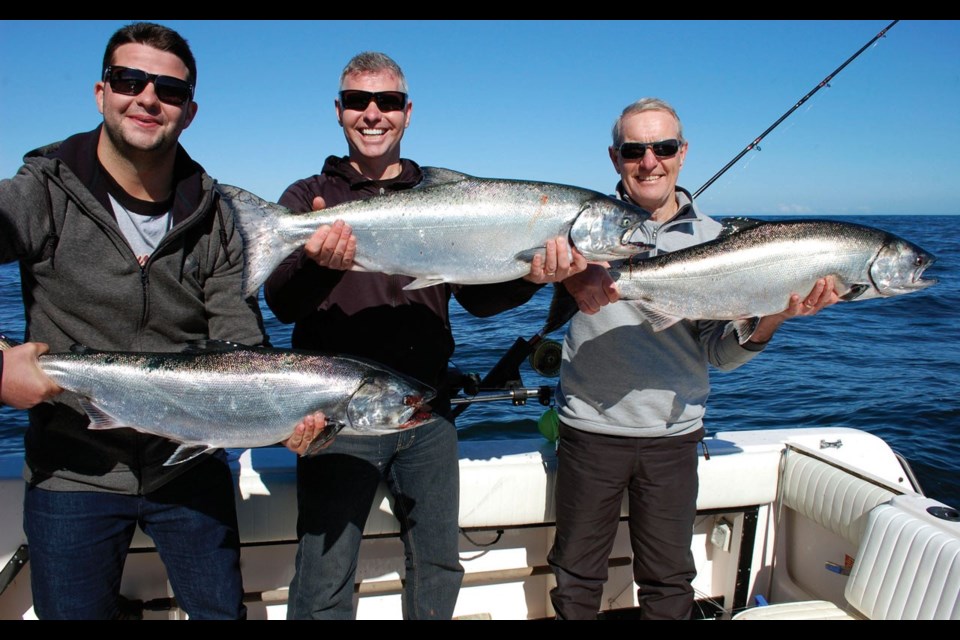 Three generation haul Alex MacNaull, left, his dad, Steve, and his grandpa, Bob, show off their catch of Chinook salmon. By Wade Dayley