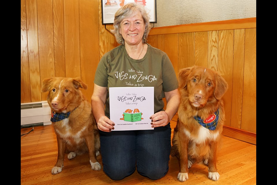 STORY TIME: qathet region author Isabelle Southcott, flanked by her Nova Scotia duck tolling retrievers Jigs [left] and Zunga, will be reading her book Toller Tales: Jigs and Zunga Take a Trip, to children in School District 47 and at Powell River Public Library as part of Family Literacy Week.                               