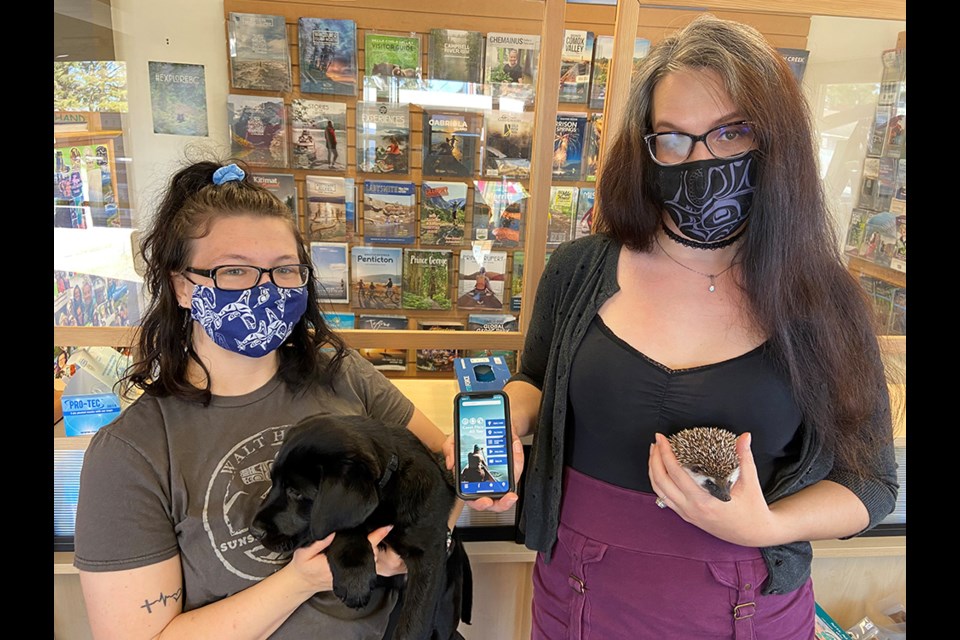 PRICKLES APPROVED: Tourism Powell River staff Melanie Ananka [left, with Jaxx] and Emily Fahey (right, with Powtown Prickles] want everyone to download the new Powell River app. The new app will have up-to-date information for visitors, residents and those who would like to become residents.