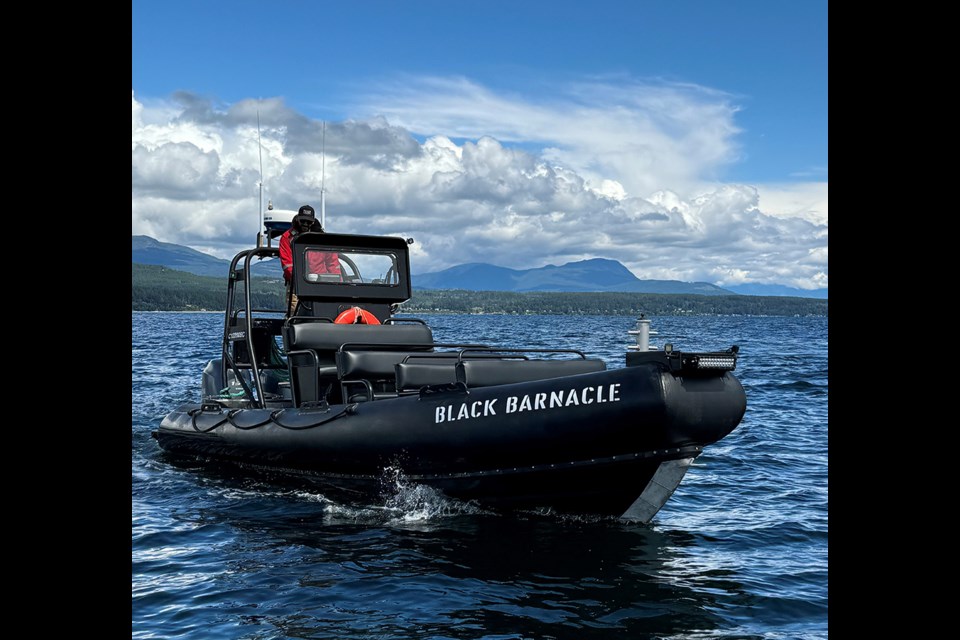 Matt Emig at the helm of the Black Barnacle, a 6.3‑metre rigid inflatable boat, he uses for Rugged Coast Expeditions, his wildlife tour company.
