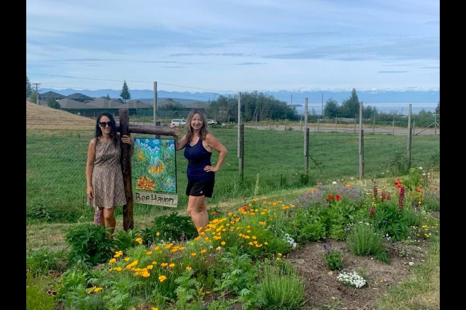 A new sign has been erected by Butterfly Rangers Claudia Bich [left] and Lesley Thorsell in a pollinating patch near Powell River Airport.