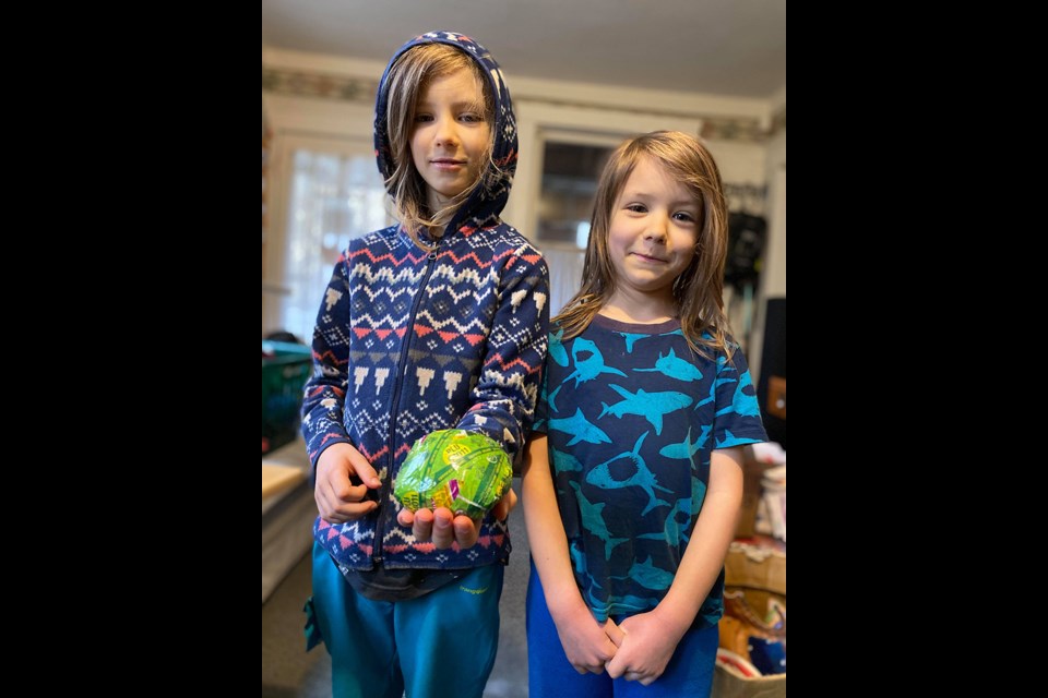 Powell River brothers Ryan [left] and Kevin McLean, and their parents, collected produce labels that came into their household over a period of one year. The resulting sticky ball weighed 130 grams.