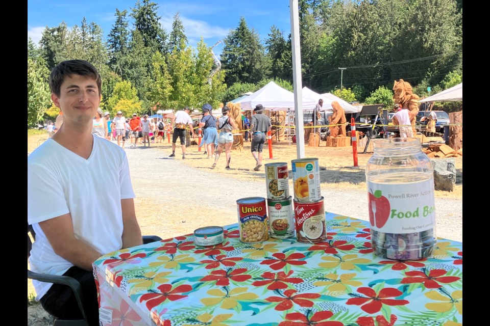 BEYOND EXPECTATIONS: Powell River Logger Sports Association collected food, cash and cheque donations from folks as they entered the free weekend-long event earlier this month. Volunteer Michael Shemming collected donations for Powell River Action Centre Food Bank at the entrance to the Loggers Memorial Bowl Amphitheatre at Willingdon Beach, where logger sports took place from July 14 to 16.