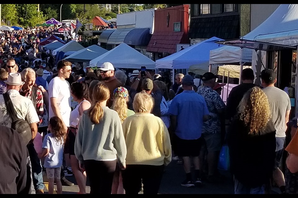 A crowd of people congregate on Marine Avenue during the Blackberry Festival street party in August of 2023.