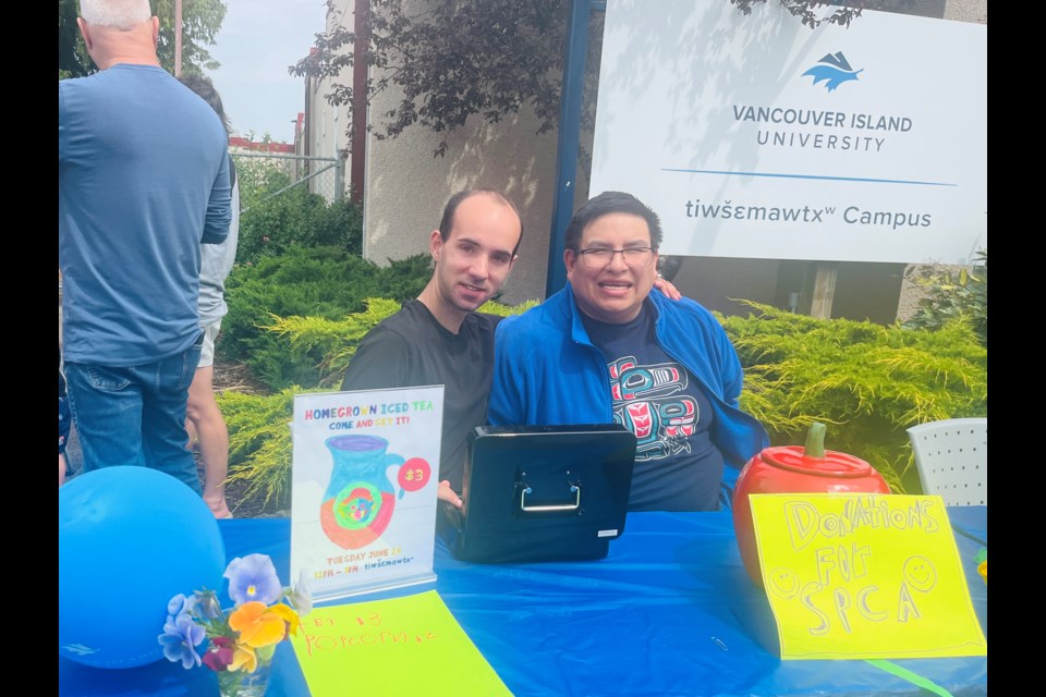WORK SKILLS: Running an iced tea and popcorn stand called Homegrown Iced Tea is part of the students' final project in the Workplace Essential Skills and Training program at VIU’s tiwšɛmawtxʷ campus. Program student Estavan LaPointe [left] and Evan Ashopenace ran the money side of the operation on June 24.
