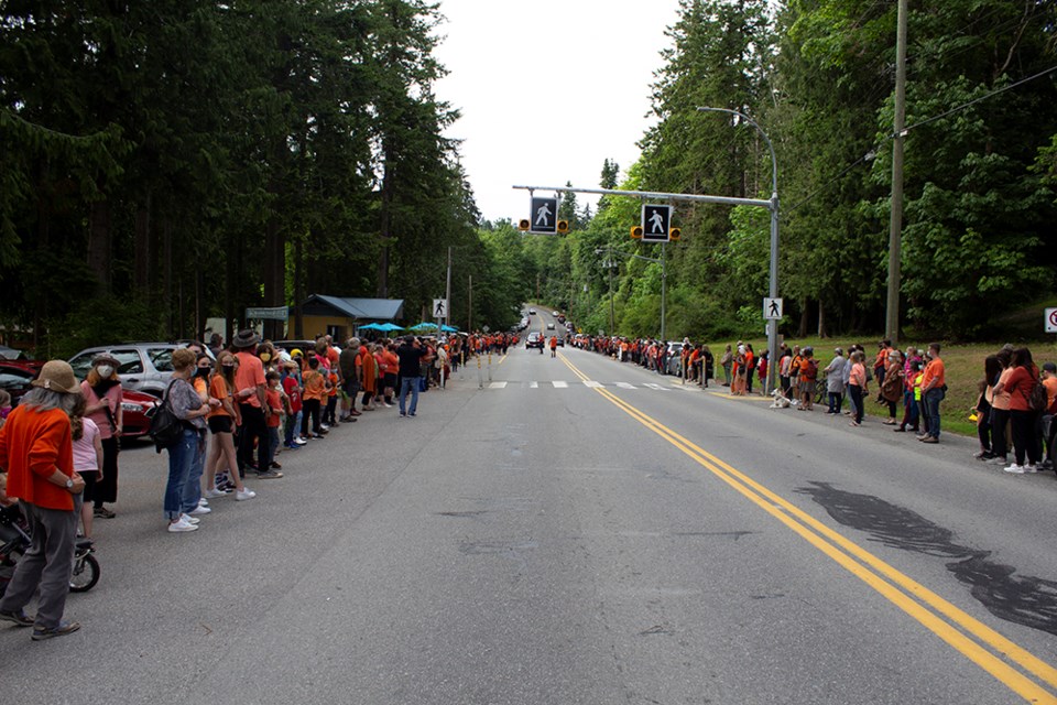 A crowd of people lined both sides of Marine Avenue at Willingdon Beach as part of events held in the qathet region to recognize the 215 First Nations' children recently found in an unmarked, undocumented burial site near a former residential school in Kamloops.