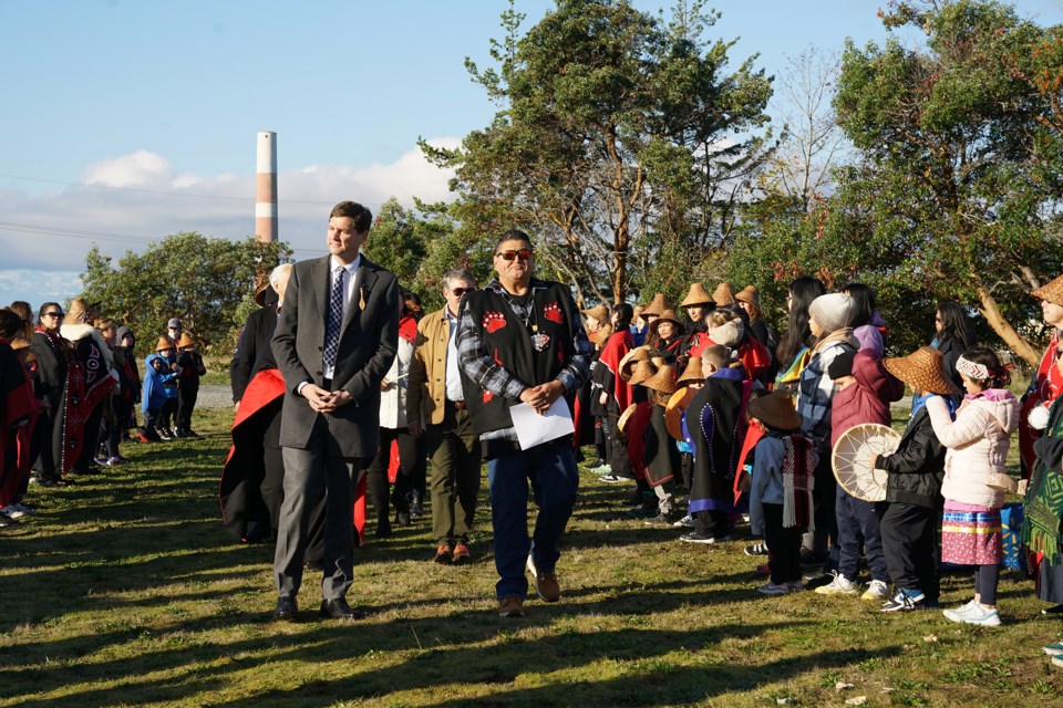 FORMER SETTLEMENT: With the old kraft mill stack servicing as a backdrop to the past, BC premier David Eby and Tla’amin Nation hegus John Hackett lead a procession to the signing of a memorandum of understanding between the province and Tla’amin to support stewardship and mutually beneficial economic development at Tis’kwat, where the ceremony was held. Tis’kwat is the original village site for Tla’amin Nation.                              