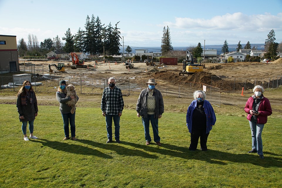  NEW RESIDENCE: Gathered in front of the construction site where Powell River Sunset Homes Society’s 34-unit apartment complex is being constructed are [from left]: society treasurer Linda Greenan, project manager CaroleAnn Leishman, with Chocolate, the dog, contractor Jim Agius, of Agius Builders, Stu Craig, society president, and society directors Ann Nelson and Marlene Gosgnach. Judy Parkhouse is also a director of the society. The society is hoping for a 15-month construction period for the seniors housing complex.                              