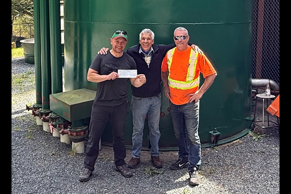 IMPORTANT DONATION: Powell River Salmon Society hatchery manager Shane Dobler [left] received a $10,000 cheque from Shaun Gloslee [centre], with Peter Giroday, which supported the careful excavation and relocation of plants from the Lang Creek salmon centre site for the enlargement of the parking lot. This is one of several projects that have been undertaken by the salmon society in recent weeks.