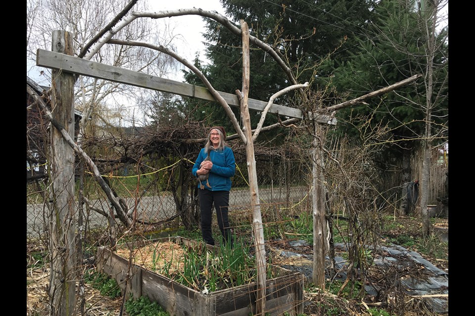 Lesley Mosely and Quackie Onassis checking out the garlic and the plant-once-and-harvest-for-years walking onions.