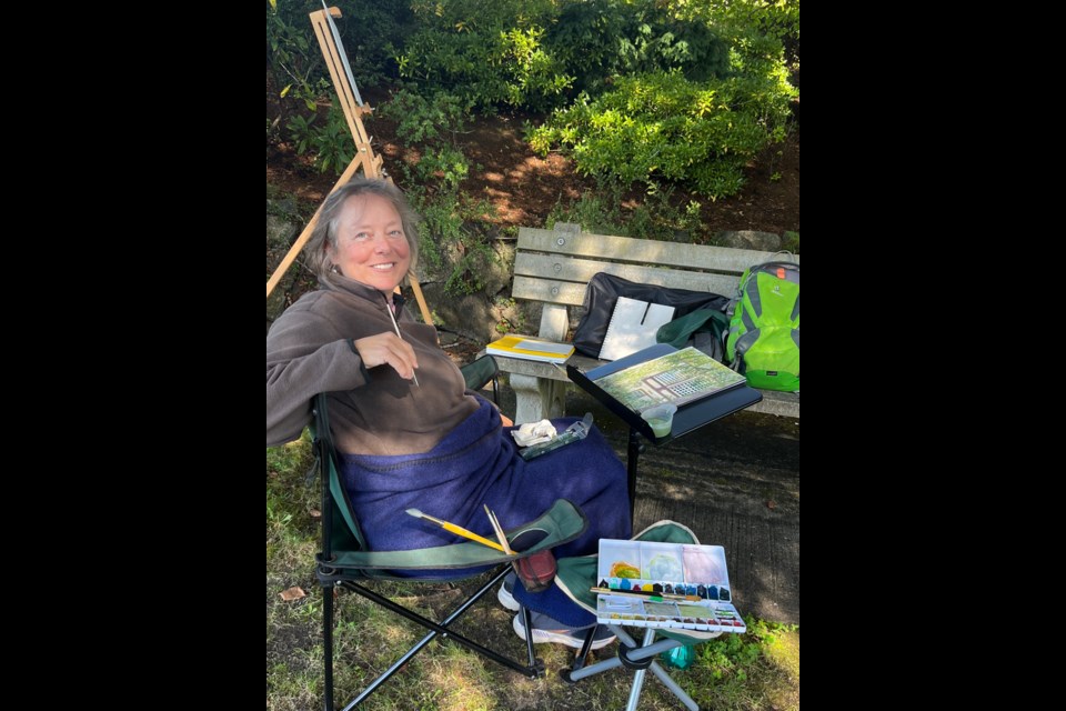 PAINTING OUTDOORS: Painter and member of Artique Artist cooperative/gallery Janet Southcott sits in Veteran’s Memorial Park outside Dwight Hall in Townsite.
