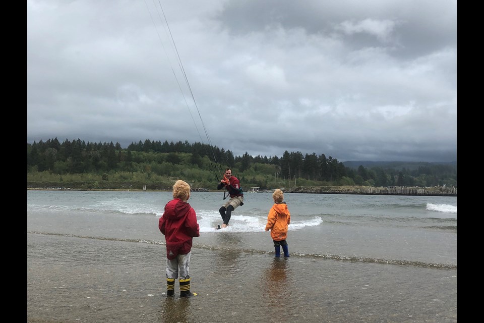 CRUISE CONTROL: Jacob Hanson takes advantage of windy conditions to return to shore at Brew Bay, south of Powell River, where his sons Hunter and Sawyer await.
