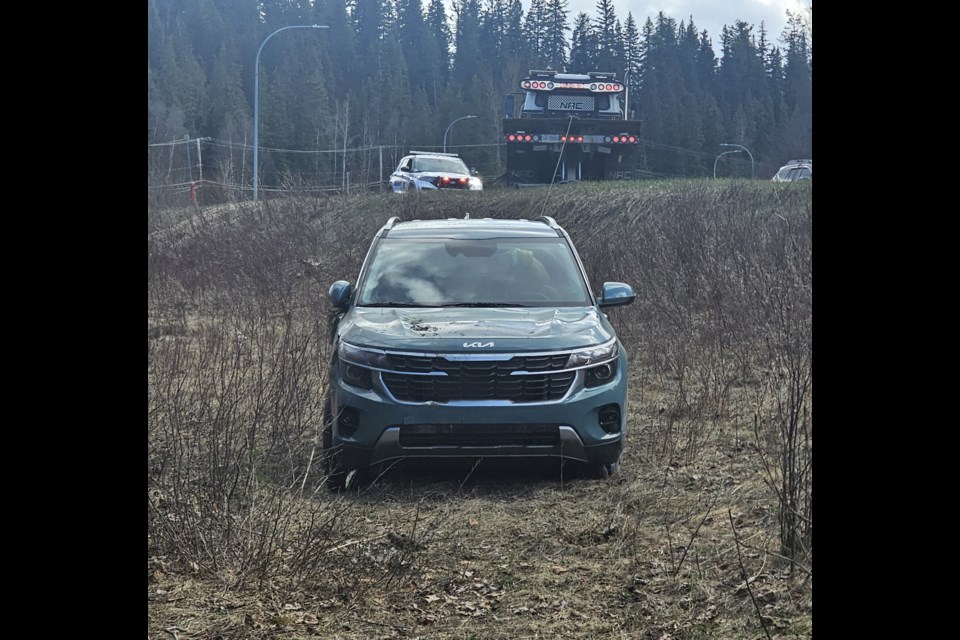 Brandyn Wickum of Ron's Towing hauls a vehicle out up an embankment after it went off the John Hart Highway on Monday, April 21, 2025 in Prince George, BC. There were no injuries.