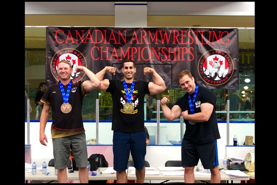 Prince George's Alex Maritsas (middle) shows off his muscles and is all smiles after winning two gold medals in Edmonton at the 2019 Canadian National Armwrestling Championships (via Contributed)