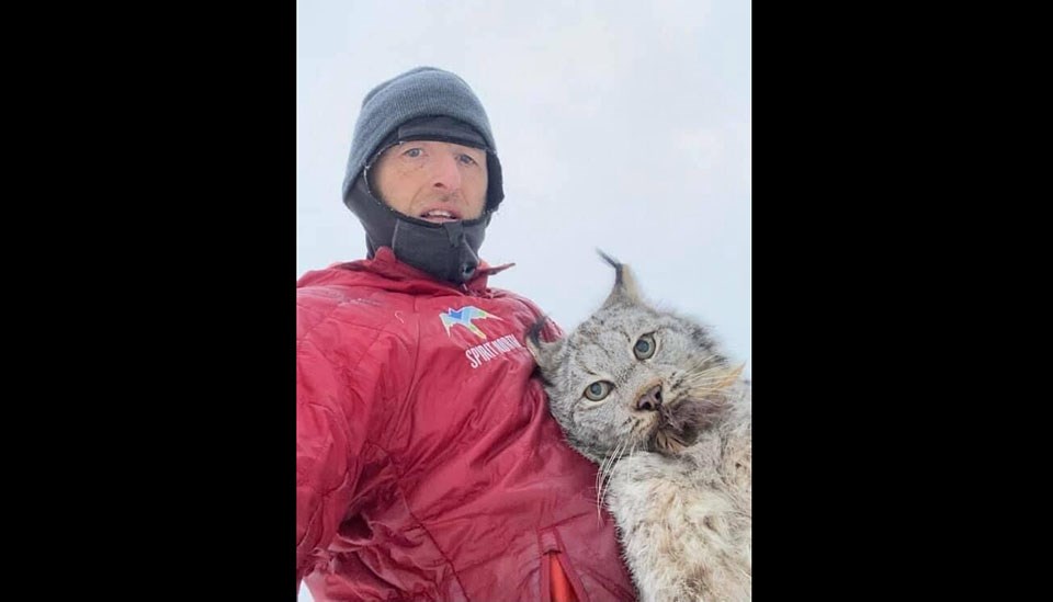 Northern B.C. resident Chris Paulson photographs himself with a lynx that killed some of his chickens after grabbing it by the scruff of the neck.