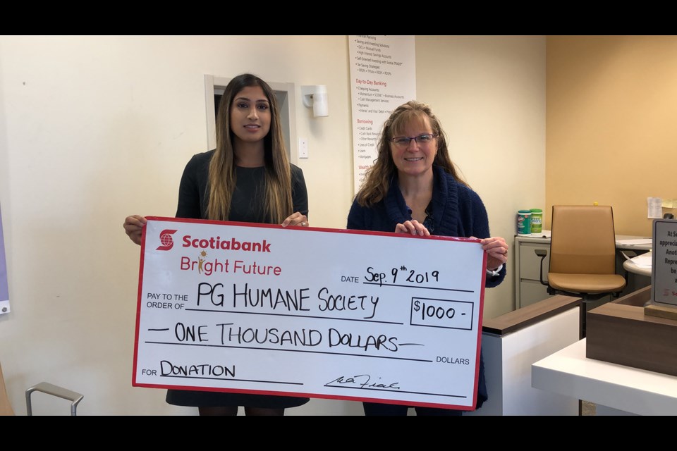 Spruceland Scotiabank Customer Service Supervisor Indy Seehra (left) and Branch Manager Wendy Fiala hold up a cheque for $1,000 in donation to the Prince George Humane Society (via Kyle Balzer)