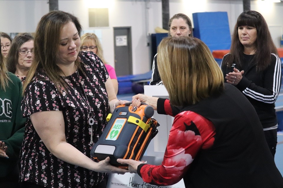 Shirley Bond presents a brand new defibrillator for the Prince George Gymnastics Club (via Kyle Balzer)