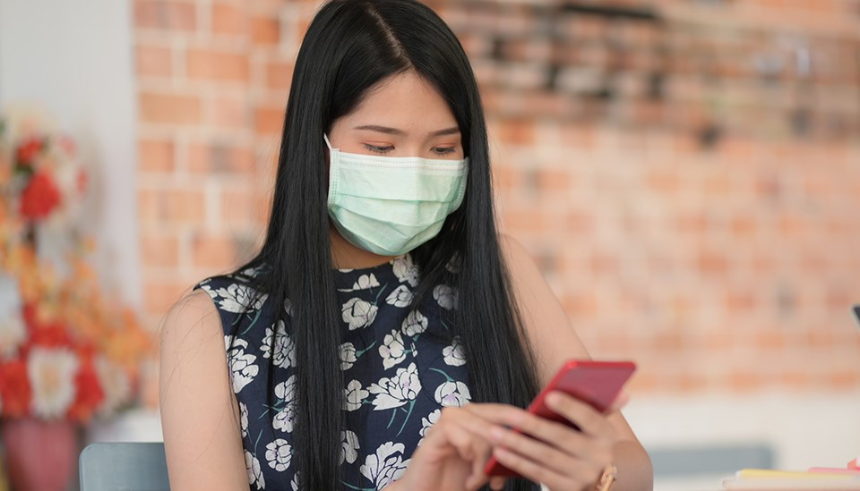 masked person uses cellphone