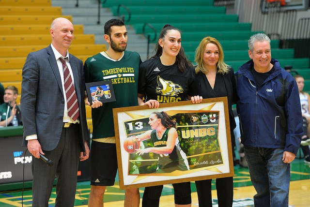 Vasiliki Louka (middle) stands with her brother Vaggelis (2nd left) and other UNBC representatives on 2019 seniors night. They have both since gone on to play professionally in Europe. | UNBC Athletics