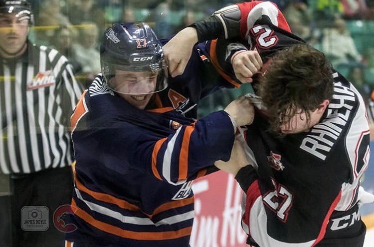 Rhett Rhinehart (#27) gets into a scrap against a Kamloops Blazer at the CN Centre (via Prince George Cougars/James Doyle Photography)