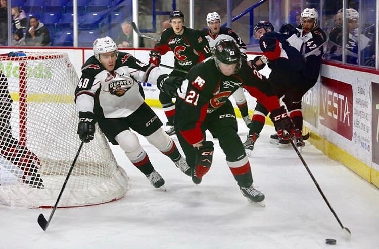 Connor Bowie (#21) carries the puck behind the net in a road game for the Prince George Cougars against the Vancouver Giants (via Vancouver Giants/Rik Fedyck Photography)
