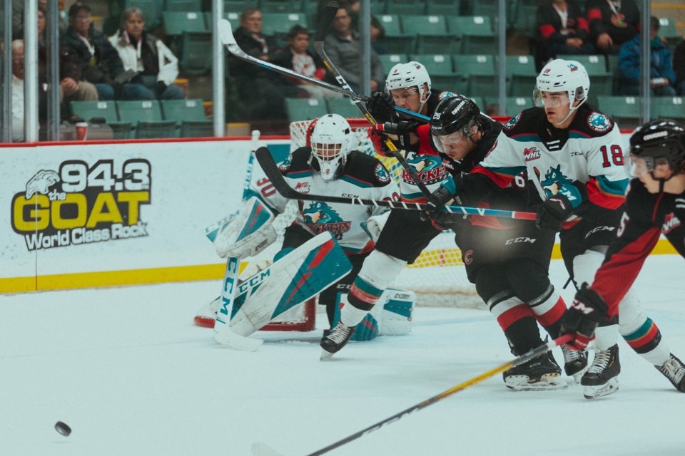 Reid Perepeluk (#26) gets caught between several Kelowna Rockets in fighting for a loose puck at the CN Centre (via Prince George Cougars/Brett Cullen Photography)