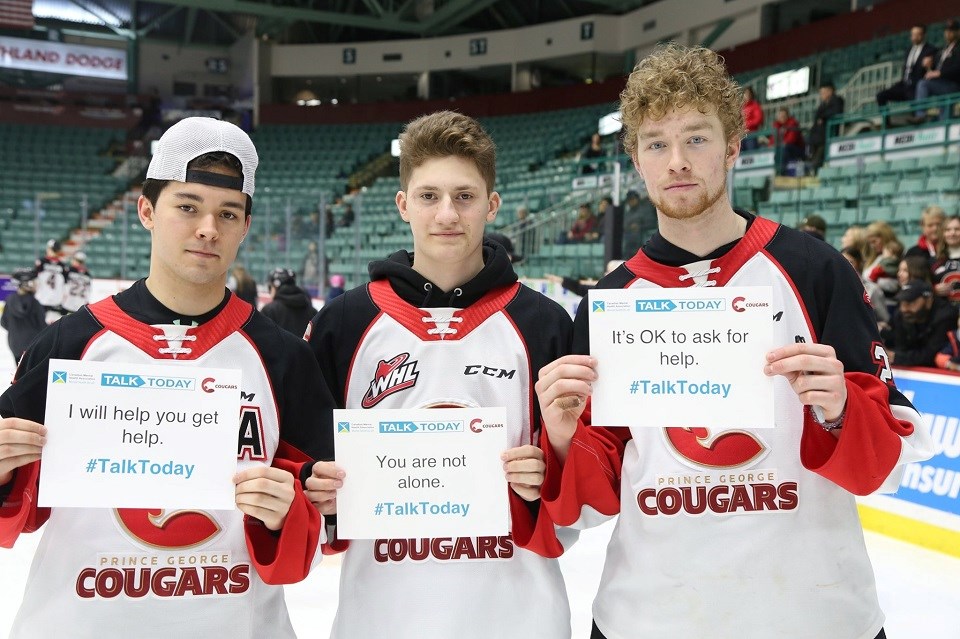 [From left to right] Ilijah Colina, Davin Griffin and Connor Bowie hold up signs showing their support in the battle against mental health issues. The Cougars are hosting Talk Today Game on Feb. 26, 2020. (via Prince George Cougars)