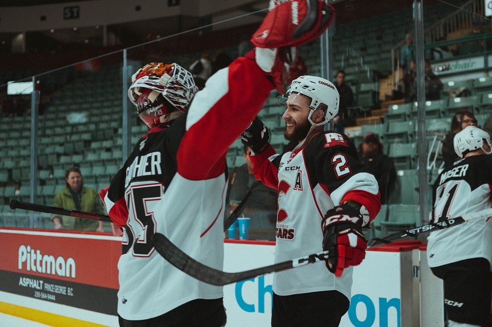 Prince George Cougars' Taylor Gauthier and Cole Moberg hug it out after beating the Seattle Thunderbirds in a shootout at the CN Centre (via Brett Cullen Photography)