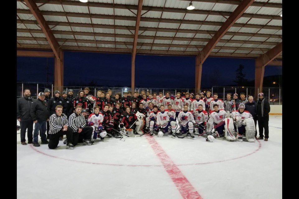 The Cariboo Cougars and Vancouver Northeast Chiefs pose for a photo after the first-ever outdoor major midget hockey game in Fort St. James (via Twitter/Nak'azdli Whut'en)